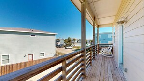 A wooden deck with a view of a beachside building. - GV628, Shared Pool, Pet Friendly, Charcoal Grill, Close to Beach (Port Aransas)