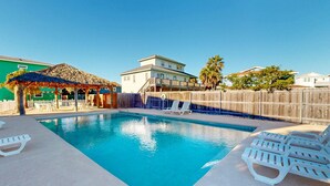 A swimming pool with lounge chairs and a shaded area. - GV634, Shared Pool, Pet Friendly, Charcoal Grill, Close to Beach (Port Aransas)