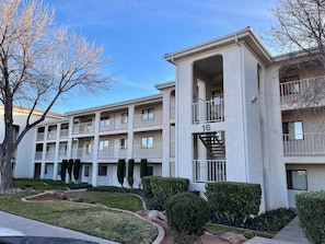 A multi-story residential building with a central courtyard, balconies, and a stairwell. - The Shandeau: Las Palmas Luxury Condo Overlooking Pools and waterpark. (St. George)