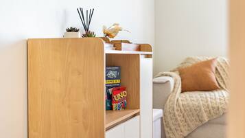A wooden bookshelf with books and a UNO game box.