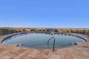 A circular pool with a metal railing, surrounded by a tiled deck and a metal fence. - Experience oceanfront luxury at 32 Ocean Place, a cozy 2-bedroom condo in Fernandina Beach. (Fernandina Beach)