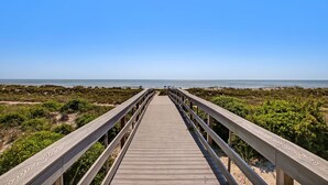 A wooden boardwalk leading to a beach with clear skies. - Experience oceanfront luxury at 32 Ocean Place, a cozy 2-bedroom condo in Fernandina Beach. (Fernandina Beach)