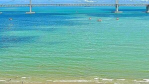 A coastal view with a bridge, clear blue water, and boats. - SainTree Hotel (Incheon)