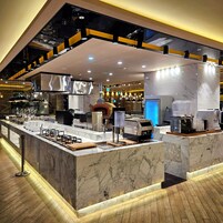 Une cuisine moderne dotée de plans de travail en marbre, d’un four encastré et d’un espace dédié à la préparation du café.