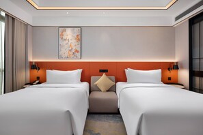 A hotel room with two beds, a neutral color scheme, a decorative wall piece, and a small seating area. - Hilton Garden Inn Leshan Shizhong (Leshan)
