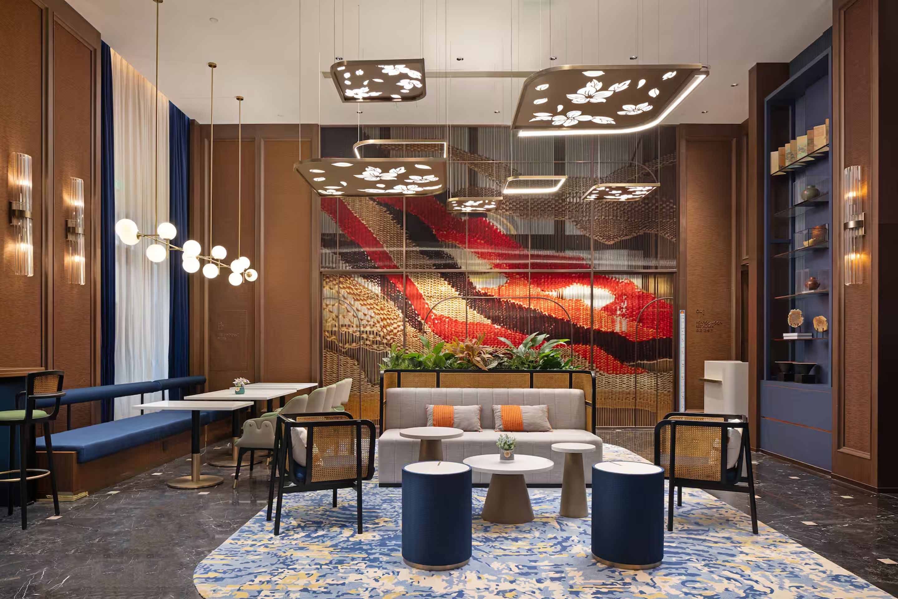 A modern lounge area with seating, tables, and decorative lighting.
