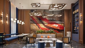 A modern lounge area with seating, tables, and decorative lighting. - Hilton Garden Inn Leshan Shizhong (Leshan)