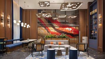 A modern lounge area with seating, tables, and decorative lighting.