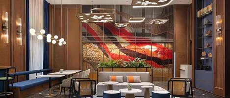 A modern lounge area with seating, tables, and decorative lighting.