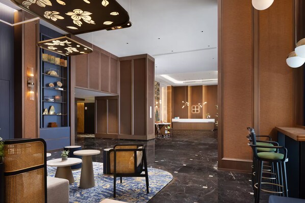 A modern lobby with a reception desk, seating area, and decorative lighting. - Hilton Garden Inn Leshan Shizhong (Leshan)