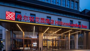 The exterior of Hilton Garden Inn with a modern facade, large glass entrance, and prominent signage. - Hilton Garden Inn Leshan Shizhong (Leshan)