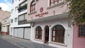 Ein Hotel namens Paseo Güemes mit weißer Fassade, Rundbogenfenstern und einem gut sichtbaren Eingang.