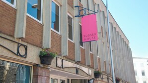 A building with a sign reading "Sussex House" and a brick facade. - Celador Apartments - Sussex House (Reading)