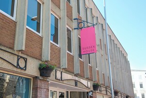 A building with a sign reading "Sussex House" and a brick facade.