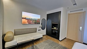 Una sala moderna con un sofá, un televisor de pantalla plana, una chimenea y una puerta.