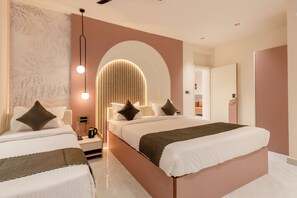 Quarto de hotel moderno com duas camas, uma mesa de cabeceira e luminária fixada na parede.