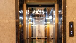 An elevator with a green carpet and a sign that reads "Legacy Inn." - Legacy Inn, Mysore (Mysore)