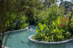 Une piscine entourée d’une végétation luxuriante et de plantes tropicales.