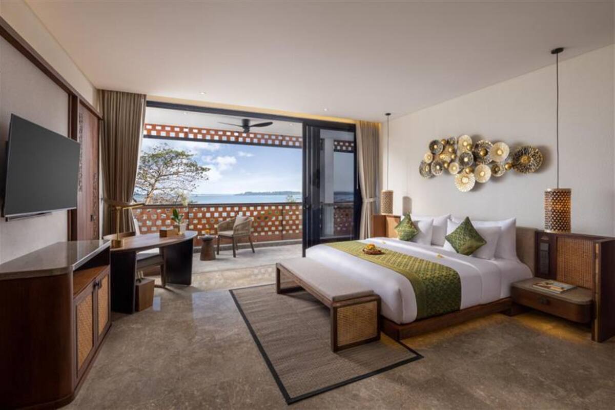Une chambre d’hôtel avec un grand lit, un bureau, une chaise et un téléviseur.