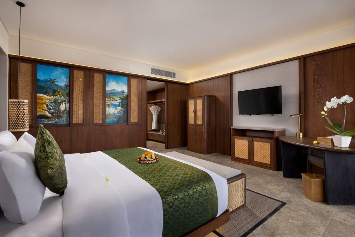 Une chambre d’hôtel équipée d’un lit, d’une armoire, d’un bureau et d’une télévision.