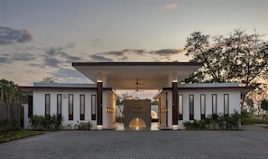 Un bâtiment moderne doté d’une entrée couverte, d’une arche centrale et d’une allée pavée.