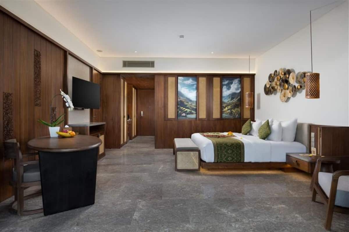 Een moderne hotelkamer met een groot bed, een televisie, een bureau en uitzicht op de bergen.