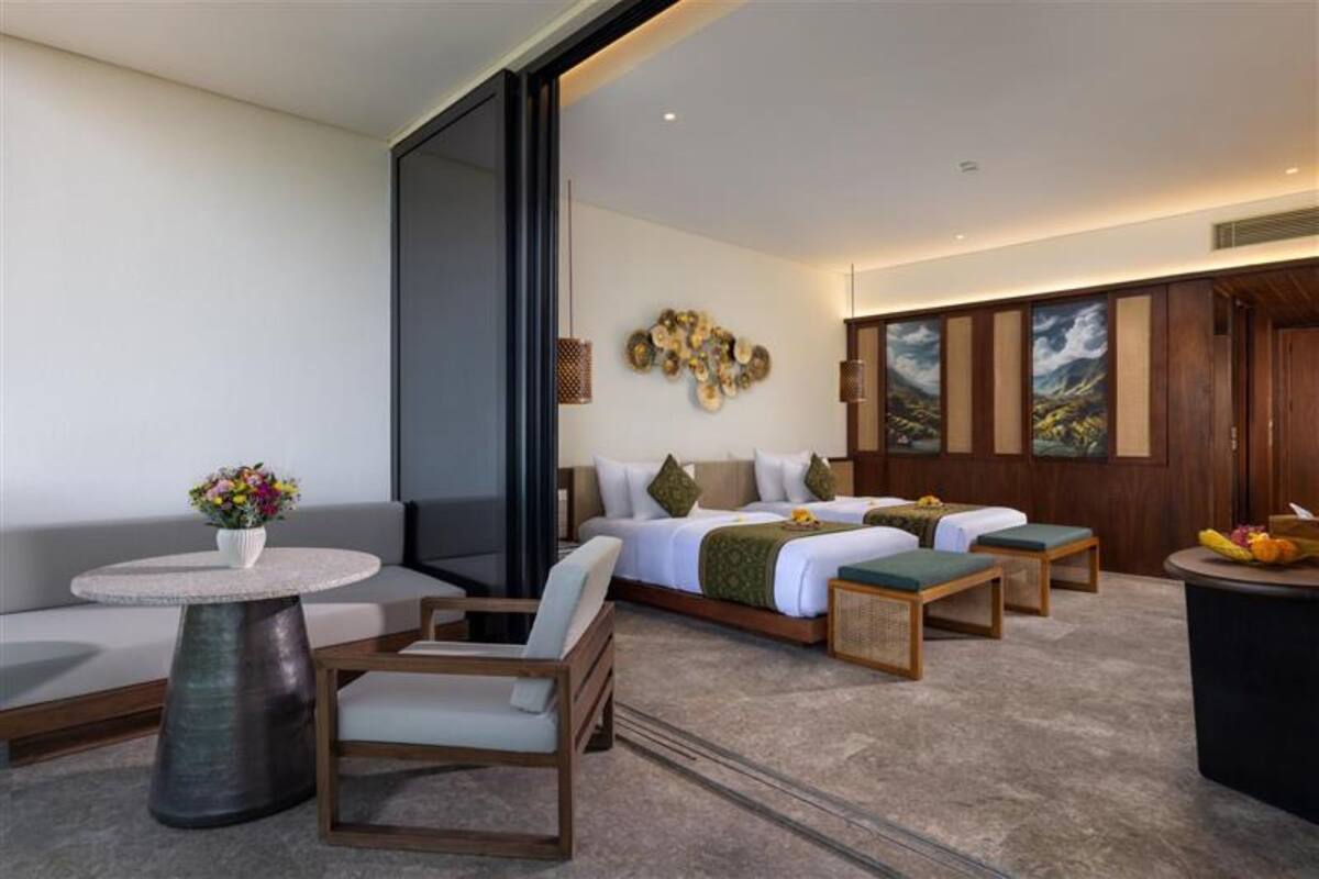 Une chambre d’hôtel moderne avec un grand lit, un canapé, une petite table et une chaise.