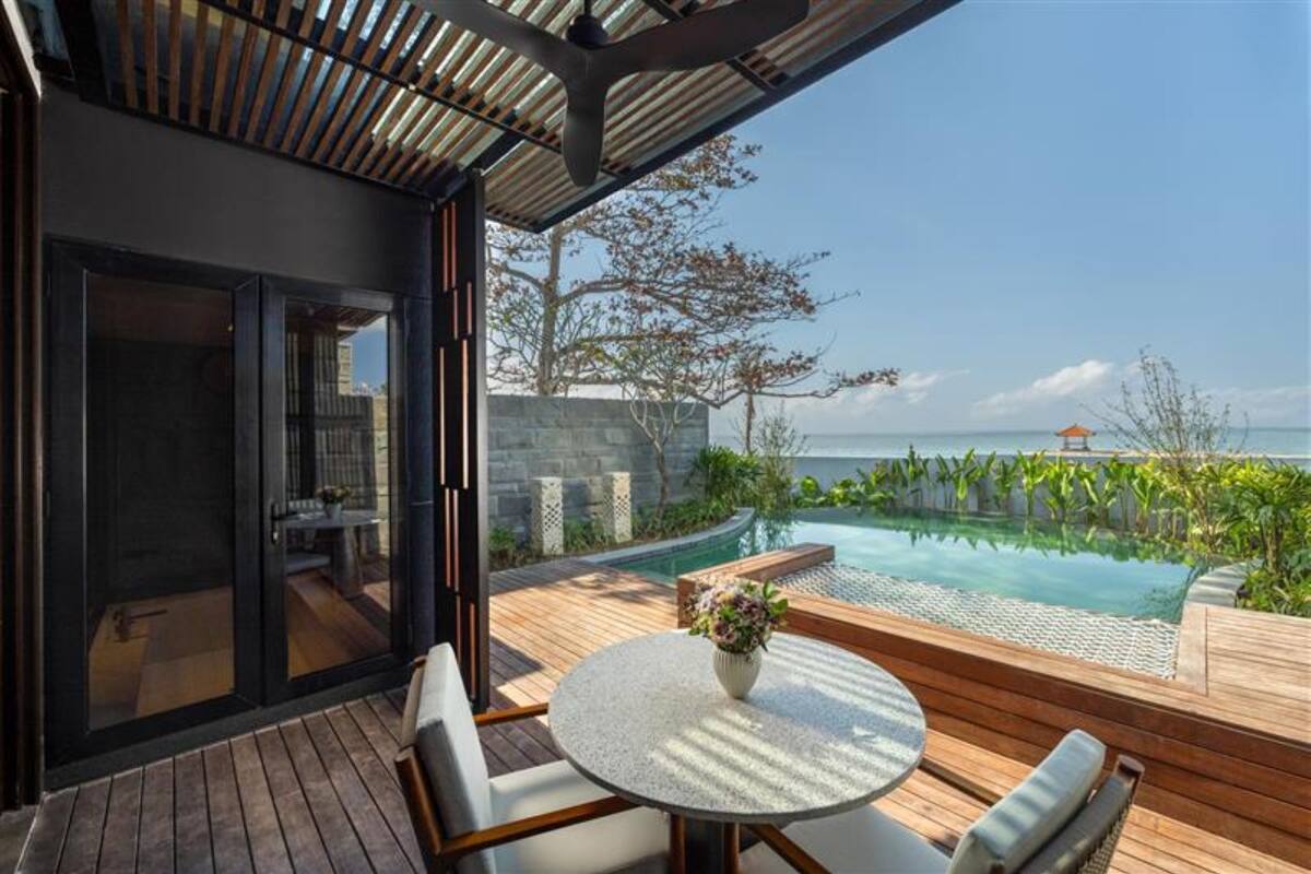 Un espace extérieur moderne doté d’une piscine, d’une terrasse en bois et de coins salon.