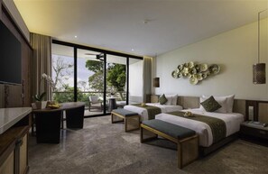 Een moderne hotelkamer met een groot bed, twee nachtkastjes, een bureau en een balkon met uitzicht op bomen.