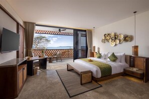 Een hotelkamer met een groot bed, een bureau, een stoel en een televisie.