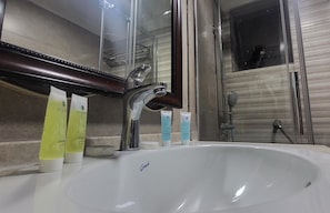 Une salle de bain avec un lavabo blanc, un miroir et des articles de toilette.