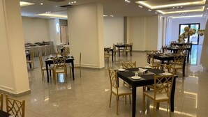 A spacious dining area with multiple tables and chairs, arranged in a modern, well-lit setting. - Jordan View Hotel (Amman)