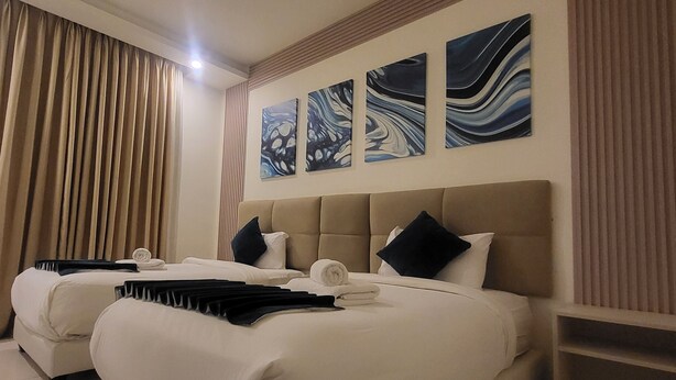 A hotel room with two beds, beige headboards, and three abstract paintings on the wall. - Jordan View Hotel (Amman)