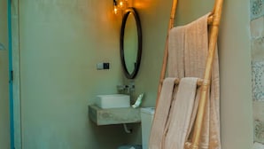 Et badeværelse med toilet, håndvask og håndklædestang.