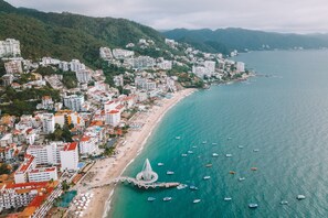 A coastal cityscape with buildings, a beach, and boats. - Casa Maria Hotel Vallarta (Puerto Vallarta)