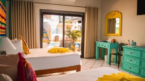 Ein Hotelzimmer mit Bett, Schreibtisch, Spiegel und Blick ins Freie.