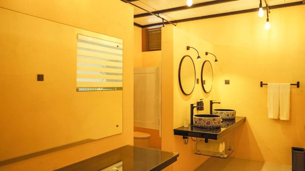 A bathroom with two sinks, a mirror, and a towel rack.