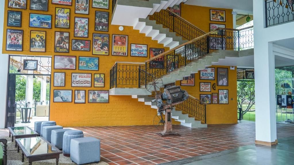 A multi-level interior with a staircase, yellow walls, and numerous movie posters.