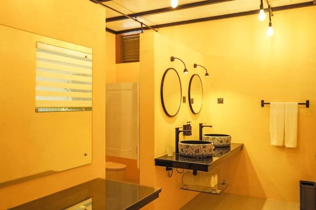 A bathroom with two sinks, a mirror, and a towel rack.