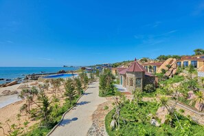 A resort with a pool, a pathway, and a view of the sea. - Adora Bay Ke Ga Beach Resort (Tan Thanh)