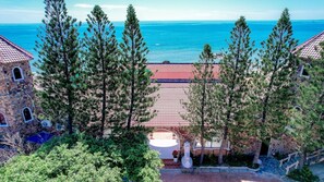 A coastal property with a tiled roof, stone buildings, and a view of the sea. - Adora Bay Ke Ga Beach Resort (Tan Thanh)
