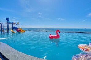 A swimming pool with a slide and a pink flamingo float. - Adora Bay Ke Ga Beach Resort (Tan Thanh)