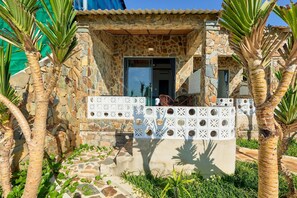 A stone building with a numbered door, a white decorative fence, and palm trees. - Adora Bay Ke Ga Beach Resort (Tan Thanh)