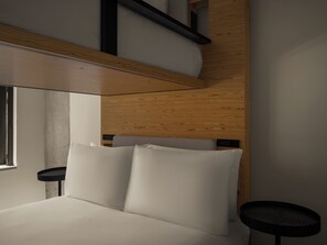 A modern bedroom with a bed, a small round table, and a wooden headboard. - Hotel 38 New York City, Tapestry Collection by Hilton (New York)