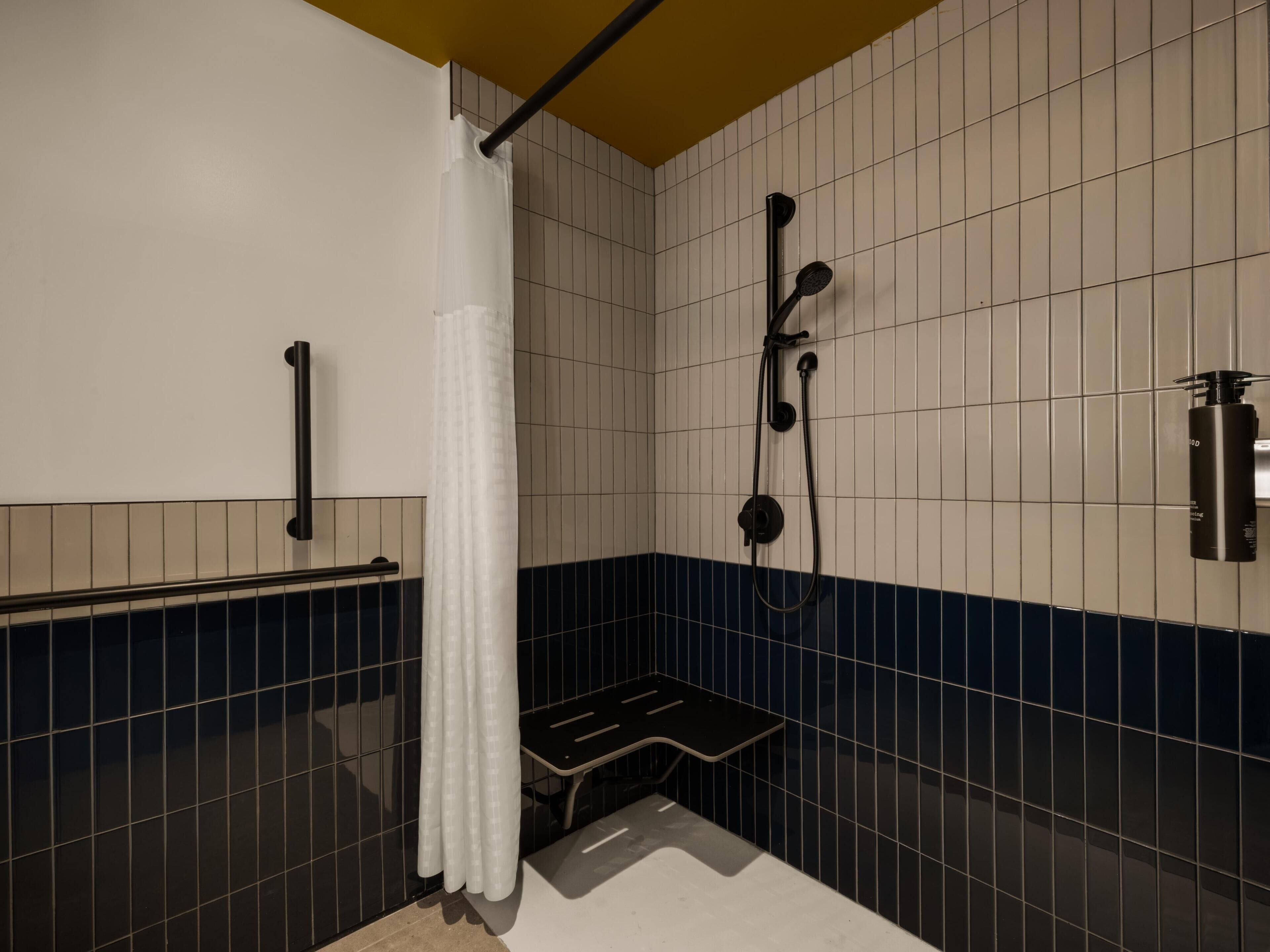 Une salle de bain avec une douche, un banc et un porte-serviettes.