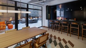 A modern interior with a dining area, bar, and seating by a large window. - Hotel 38 New York City, Tapestry Collection by Hilton (New York)