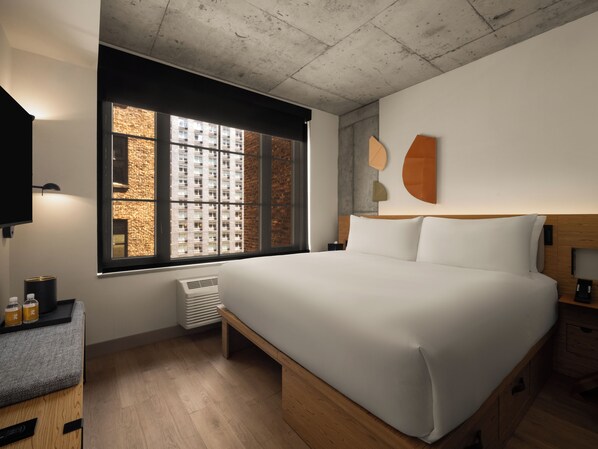 A modern hotel room with a large bed, a small bedside table, a TV, and a window with a view of a building. - Hotel 38 New York City, Tapestry Collection by Hilton (New York)