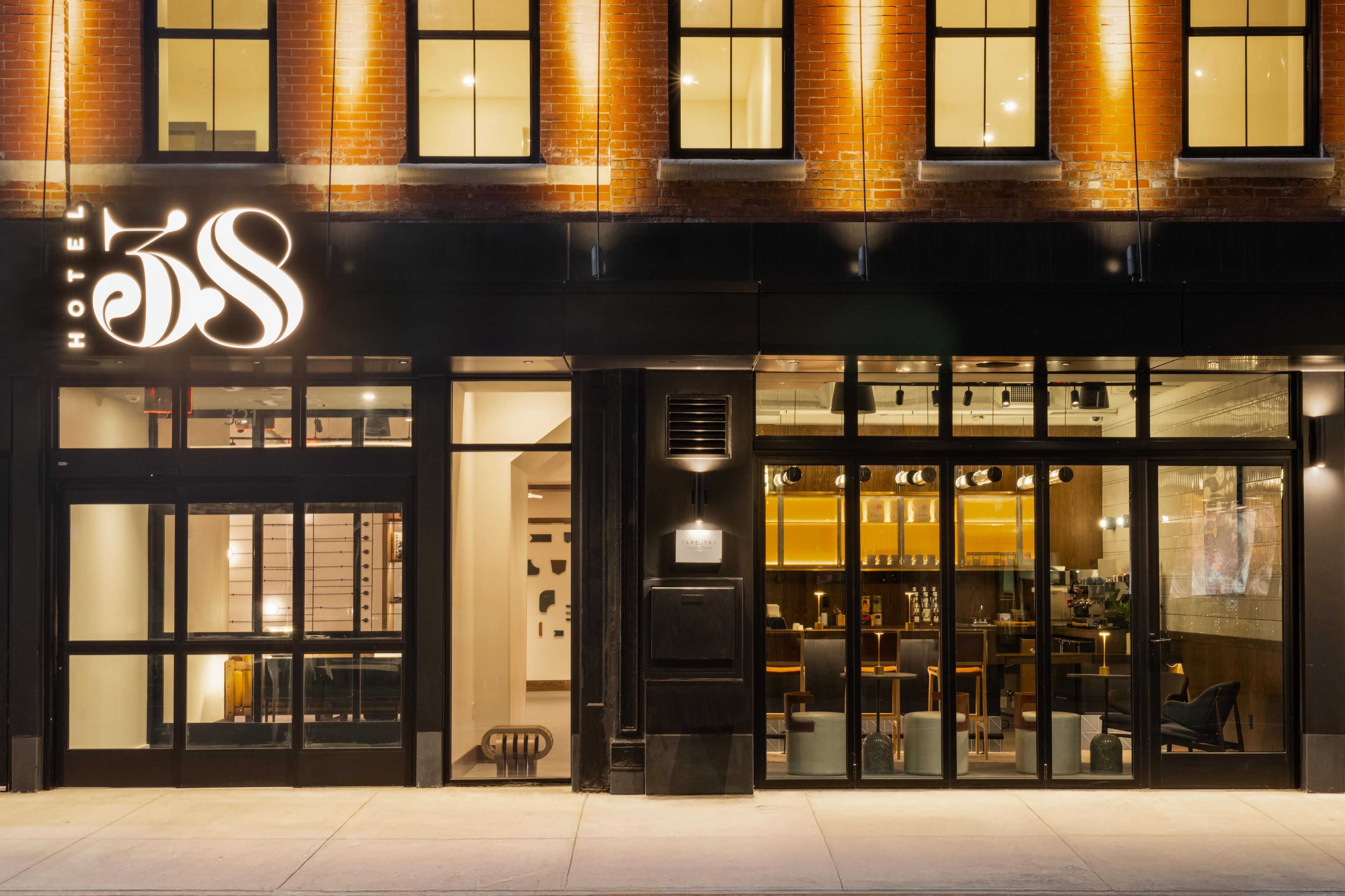 A hotel with a prominent 'Hotel 35S' sign, large glass entrance, and interior seating visible through the doors.