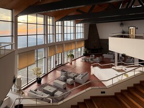 A spacious interior with large windows, a fireplace, and a staircase. - Hotel E Spa Alfândega Douro Valley (Alfandega da Fe)
