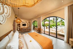 Ein geräumiges Schlafzimmer mit einem großen Bett, einem Schreibtisch und Blick auf den Außenpool.